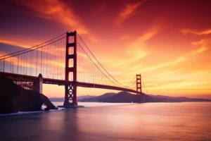 Golden Gate Bridge stretching across calm water beneath a glowing orange and rose sunset.