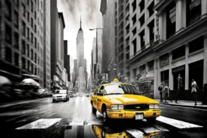 Yellow taxi on a monochrome New York street with the Empire State Building in the distance.